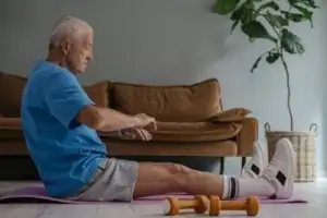 Older man exercising at home, demonstrating a lifestyle approach to naturally lower uric acid levels.
